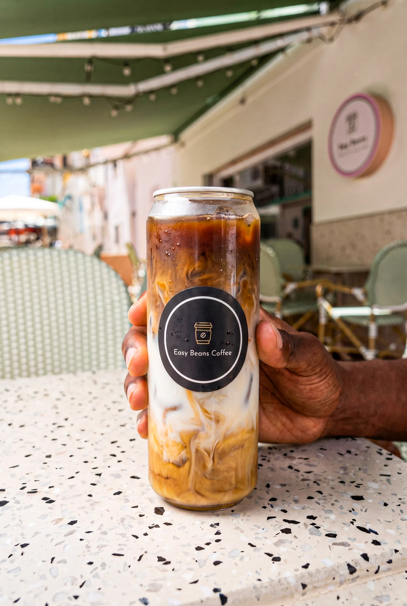 Un latte con hielo en una lata de Easy Beans, en la terraza